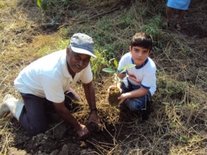 Ranger helps a child plant a tree in the Atlantic Rainforest