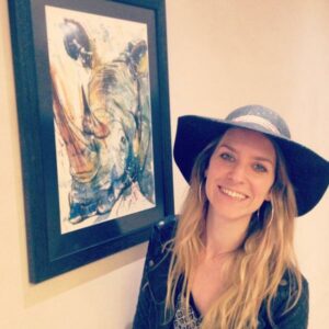 Tori Ratcliffe and one of her paintings of a Rhinoceros.