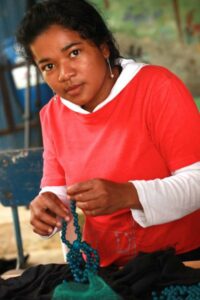 Colombian woman assembling jewellery.