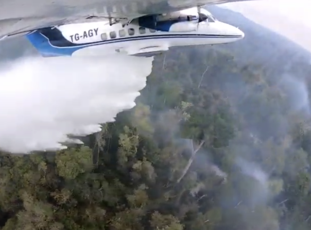 A small plane dropping water on fires in Guatemala. Credit: FUNDAECO