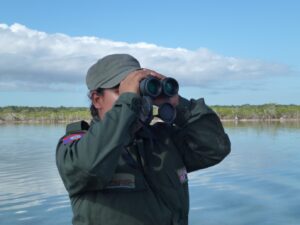 CSFI ranger in Belize, looking through binoculars
