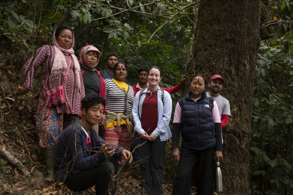 A group of people stand together in a forest. 