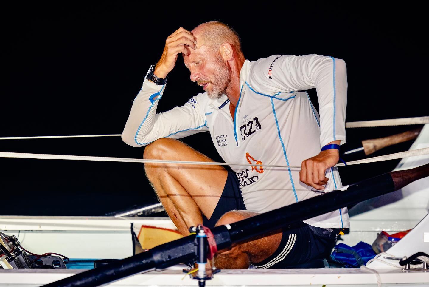Man sits tired on a rowing boat.