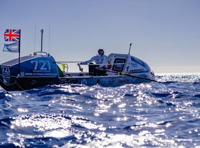 Nick Hollis sits in a rowing boat on the ocean