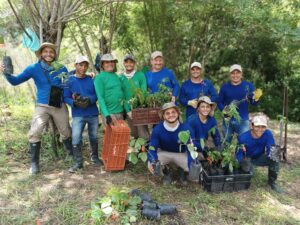 A group of rangers posing together holding saplings as part of tree planting activities.