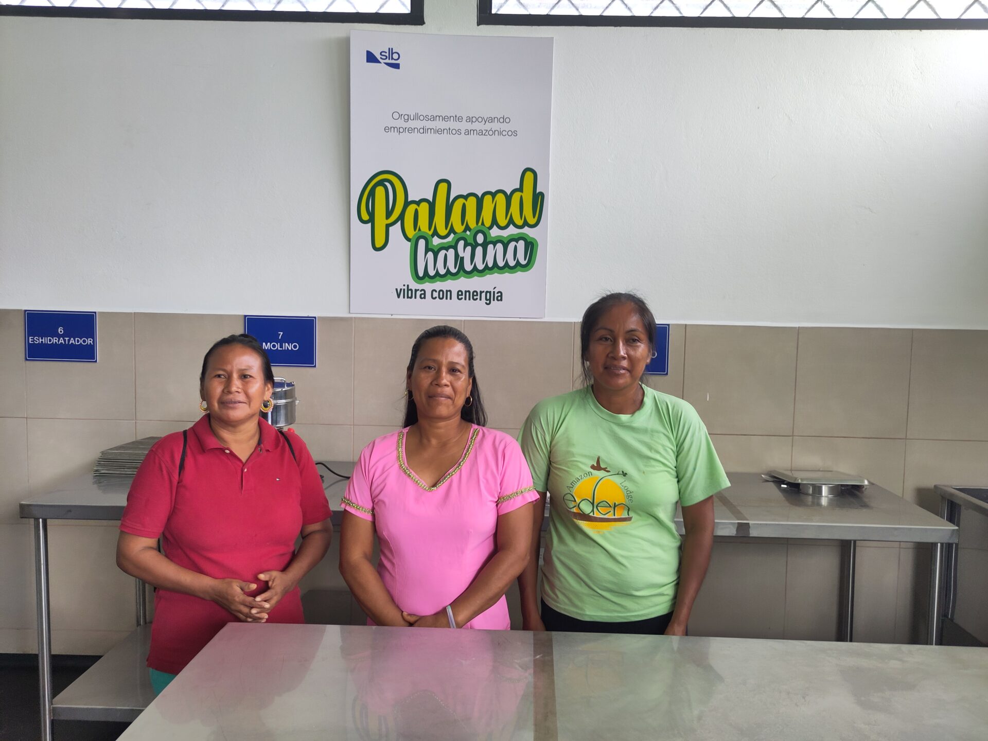 Three women standing in their community kitchen