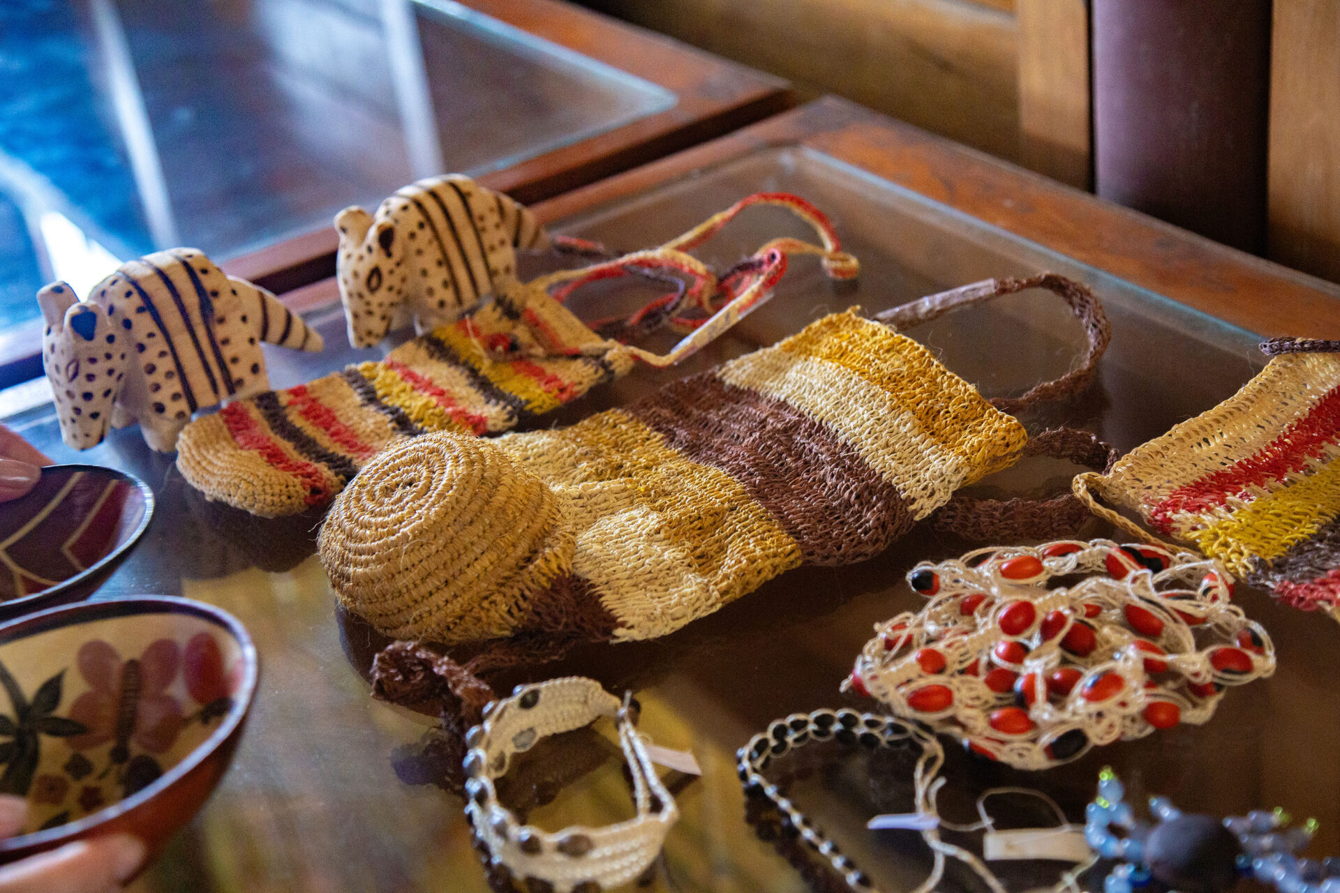 A selection of handmade arts and crafts items laid out on a glass table