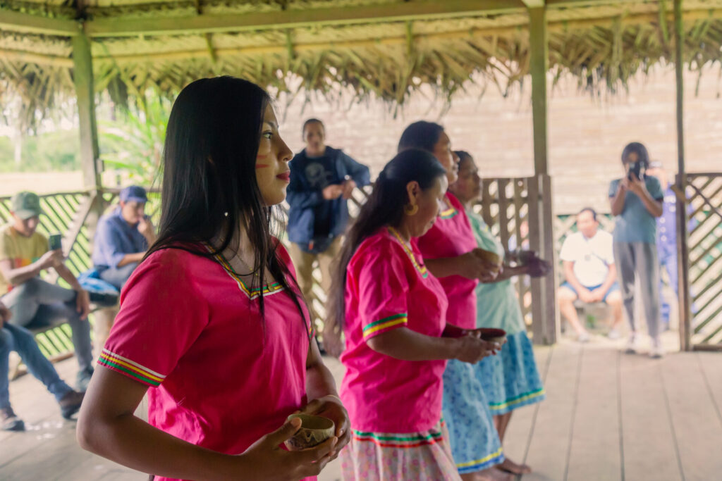 Indigenous women from the El Eden Kichwa community dancing in traditional dress.