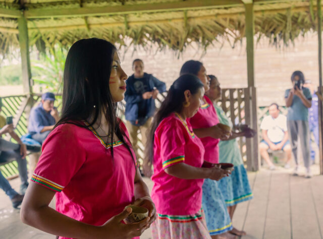 Indigenous women from the El Eden Kichwa community dancing in traditional dress.