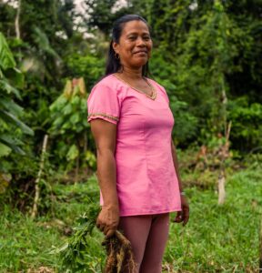 portrait of a woman standing in a chakra farm among the rainforest of Ecuador