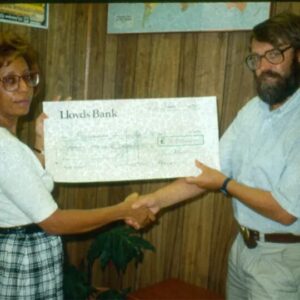 A photo of Joy Grant, PfB’s first executive director, presenting John Burton, co-founder of WLT, with a £10,000 cheque to establish the UK-based charity Programme for Belize which would later become WLT