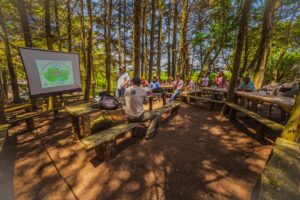 ranger giving a presentation to community members among the trees of the Honduran cloud forest