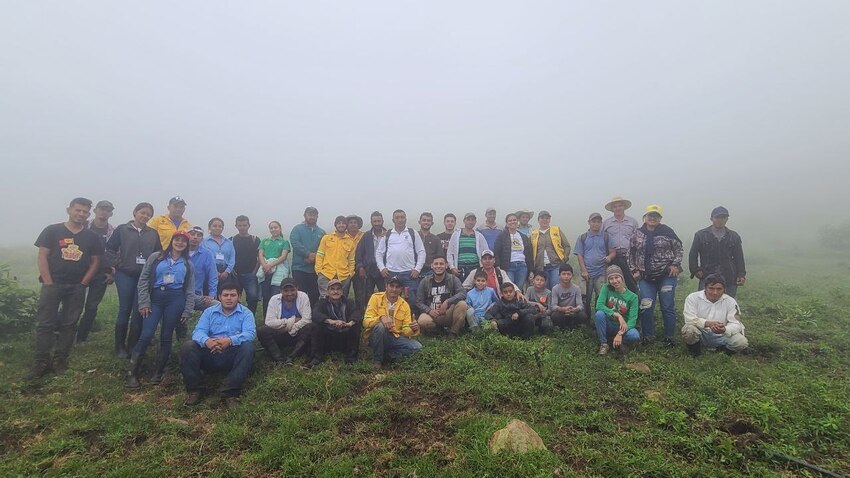 group of people posed together for a photograph with misty background. 