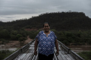 A Guarani community member stands on a bridge