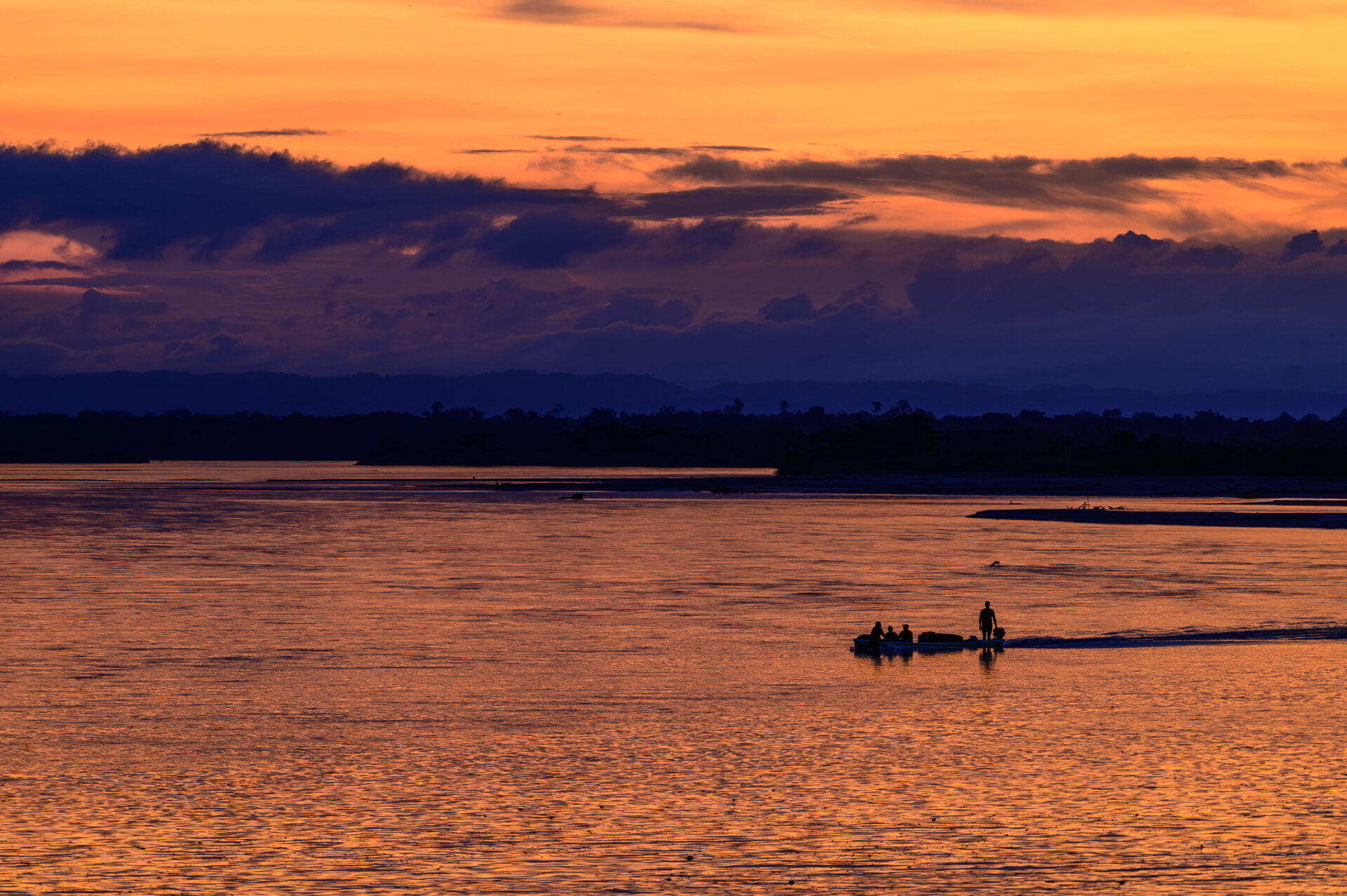 Fishermen in their boat on the wetlands at sunset.