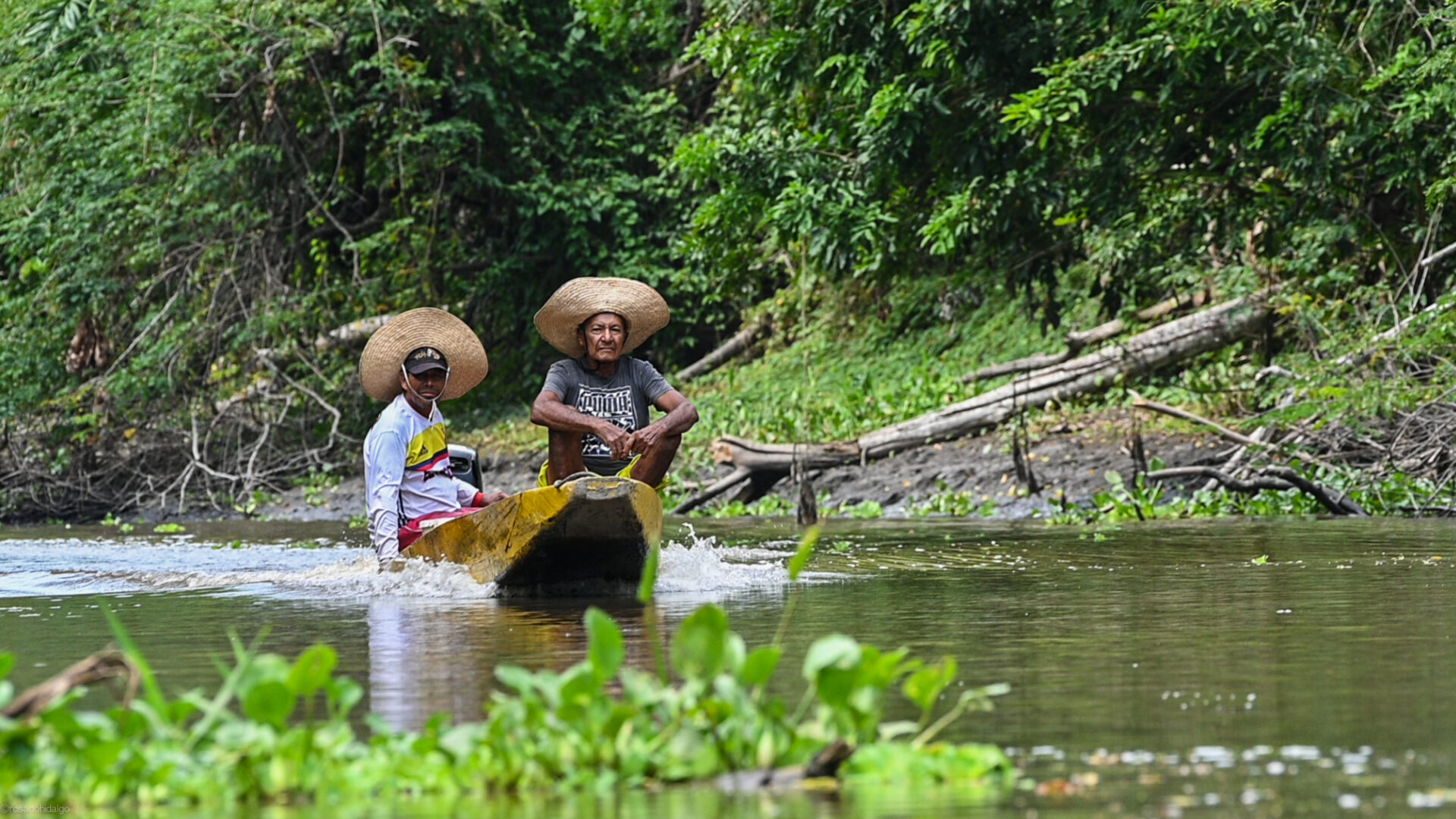 Two fisherman going down the Magdalena River in a boat