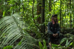 A photo of Julio Marín sitting in the forest.