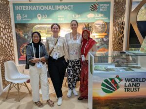 Mary and Charlotte on the World Land Trust stand with two participants from a conservation charity in Indonesia.
