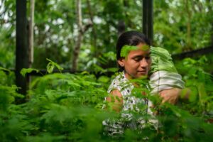 A photo of Sandra Rodríguez with her baby at the tree nursery.