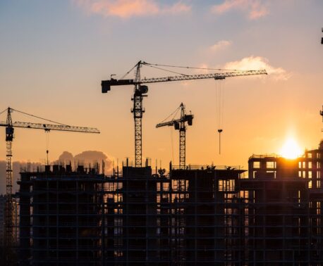 Cranes on a building site at sunset